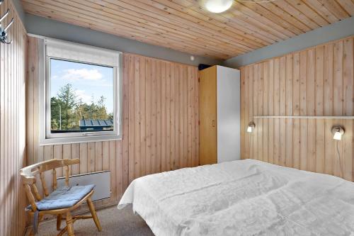 a bedroom with a bed and a window and a chair at Beautiful Home In Knebel With 3 Bedrooms in Knebel