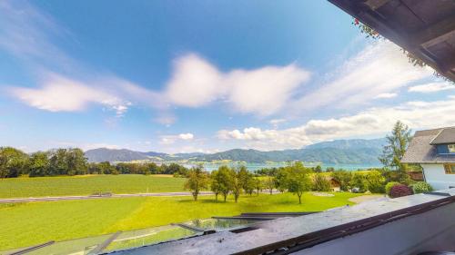 an aerial view of a green field and mountains at Hotel Haberl - Attersee in Attersee am Attersee