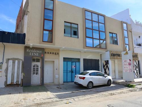 a white car parked in front of a building at Residence Lyne in Kairouan