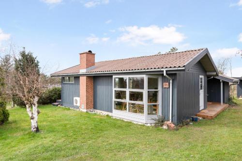 a house with a large window in a yard at Beautiful Home In Knebel With 3 Bedrooms in Knebel