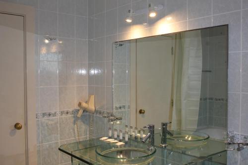 a bathroom with two sinks and a large mirror at Desalis Hotel London Stansted in Elsenham