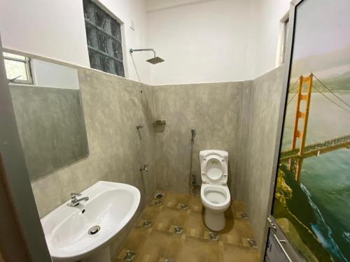 a bathroom with a sink and a toilet at The blue sky in Ahangama