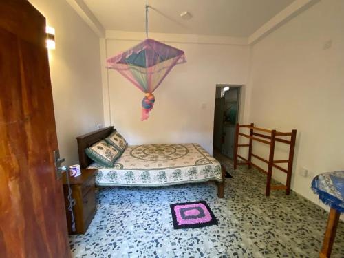 a bedroom with a bed and an umbrella on the wall at The blue sky in Ahangama