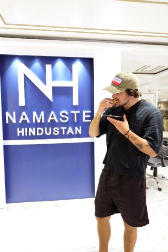 a man talking on a cell phone in front of a sign at Hotel Namaste Hindustan Just a Minute Away From New Delhi Railway Station and Connaught place in New Delhi