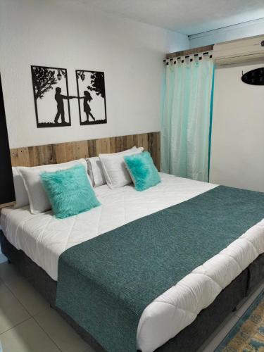 a bedroom with a large bed with blue and white pillows at ArisSha Boutique Hotel in Cali