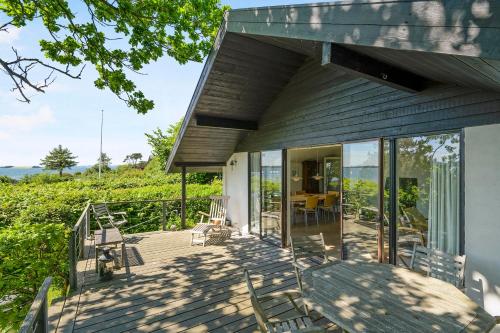 a house with glass doors and chairs on a deck at Awesome Home In Knebel With 2 Bedrooms And Wifi in Knebel