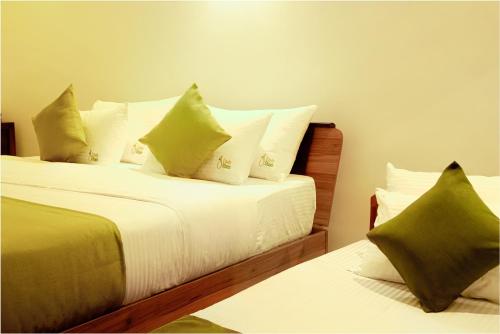 a bedroom with two beds with green and white pillows at Lindy Stays Talpe in Pitiduwa