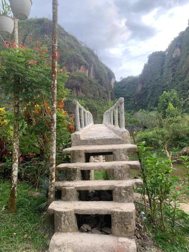 a stone bridge over a river in a mountain at Zico Homestay in Andalas