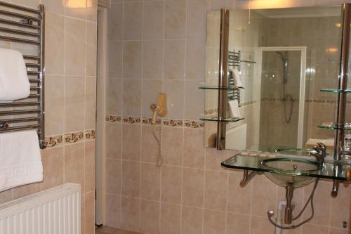 a bathroom with a glass sink and a shower at Desalis Hotel London Stansted in Elsenham