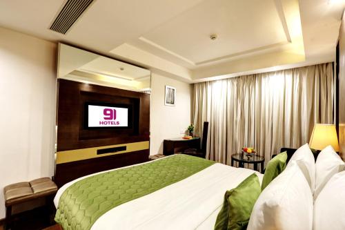 a hotel room with a bed and a television at Flute Boutique by Hotel 91 in Jaipur