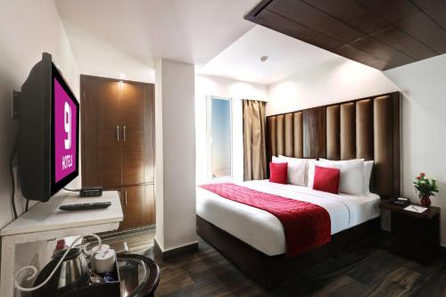 a hotel room with a bed and a television at Flute Boutique by Hotel 91 in Jaipur