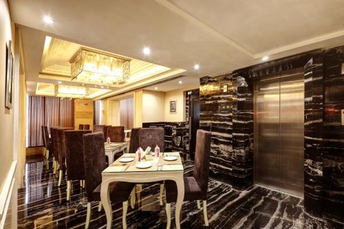 a restaurant with a table and chairs and a chandelier at Flute Boutique by Hotel 91 in Jaipur