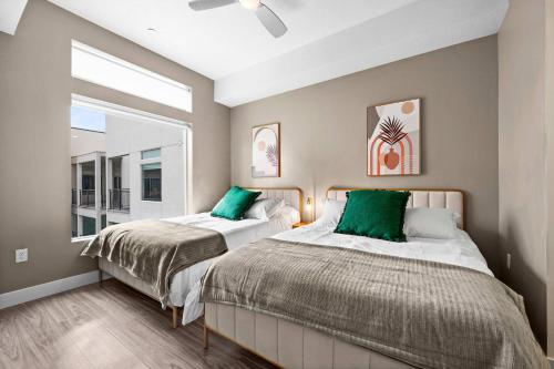 Un dormitorio con dos camas con almohadas verdes. en Luxury High-Rise Living in SLC, en Salt Lake City