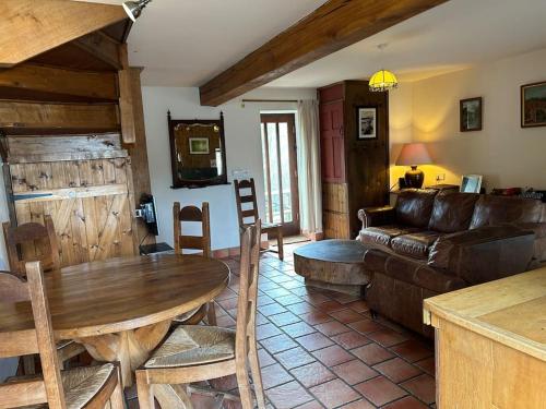 a living room with a wooden table and a couch at Happy Horse Cottages in Sennybridge