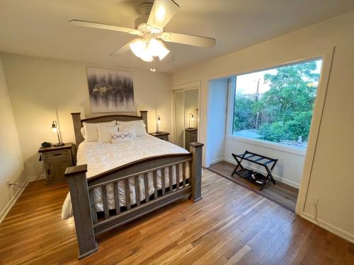 a bedroom with a bed with a ceiling fan and a window at Artsy Bohemian - 2 Min to Airport -TheGoodPlace#2 in San Antonio