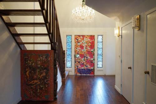 a hallway with a staircase and a painting on the door at Artsy Bohemian - 2 Min to Airport -TheGoodPlace#2 in San Antonio