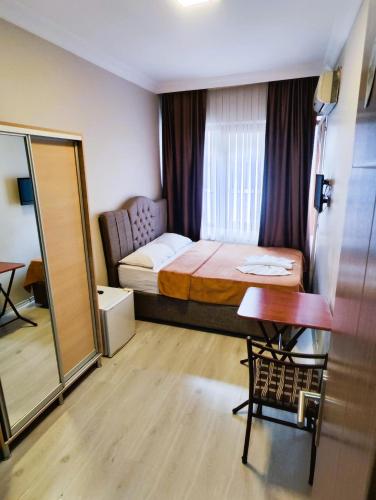 a bedroom with a bed and a table and a mirror at Birol Hotel in Istanbul