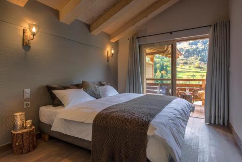 um quarto com uma cama grande e uma janela grande em A Larze em Le Châble