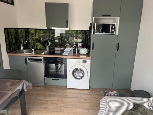 une cuisine avec un réfrigérateur et une machine à laver dans l'établissement Location havre de paix, à Gourbera
