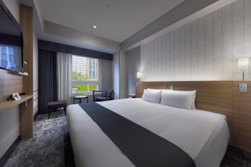a hotel room with a large bed and a window at Hotel Villa Fontaine Grand Tokyo-Roppongi in Tokyo