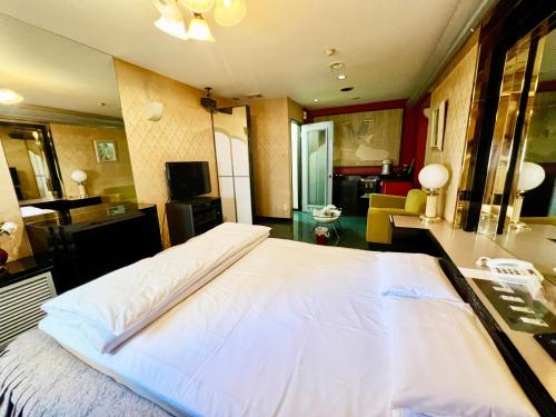 a large white bed in a large room at Hotel 21 in Nagasaki