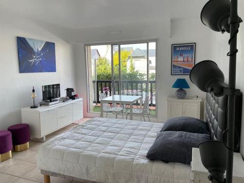 - une chambre avec un lit, une table et un balcon dans l'établissement Deauville studio en bord de mer, à Deauville