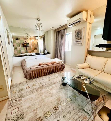a bedroom with a bed and a couch at Hotel 21 in Nagasaki