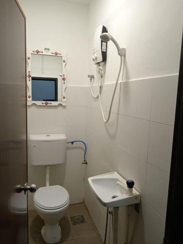 a bathroom with a white toilet and a sink at Hotel Seri Intan Tampin in Tampin