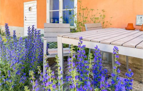 a garden with purple flowers and a wooden table at Cozy Apartment In Visby With Kitchen in Visby