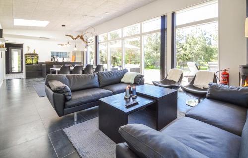 a living room with couches and a table at Amazing Home In Væggerløse With Wifi in Marielyst