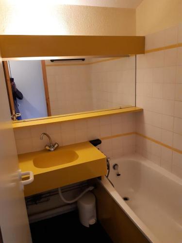La salle de bains est pourvue d'un lavabo jaune et d'une baignoire. dans l'établissement Résidence Le Sextant - maeva Home - 2 Pièces 5 Personnes Confort MAE-4595, à La Plagne Tarentaise
