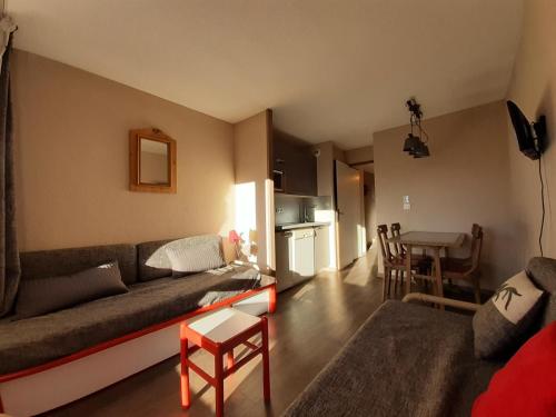 un salon avec un canapé et une table dans l'établissement Résidence Le Hameau du Sauget - maeva Home - 2 Pièces 4 Personnes Sélection MAE-3989, à La Plagne Tarentaise