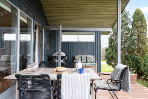 an outdoor patio with a wooden table and chairs at Beautiful Home In Knebel With 3 Bedrooms in Knebel