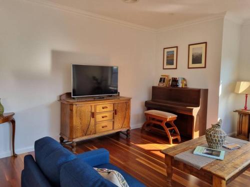 a living room with a blue couch and a television at 2 bedroom house Central Nagambie sleeps 5 in Nagambie