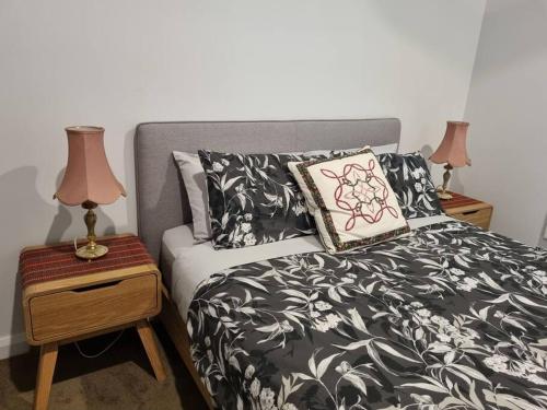 a bedroom with a bed and two night stands with lamps at 2 bedroom house Central Nagambie sleeps 5 in Nagambie
