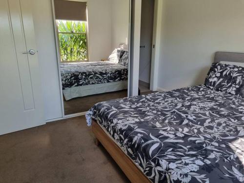 a bedroom with a bed and a mirror at 2 bedroom house Central Nagambie sleeps 5 in Nagambie