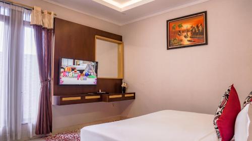 a bedroom with a bed and a mirror and a tv at Grand Sunshine Resort & Convention in Bandung