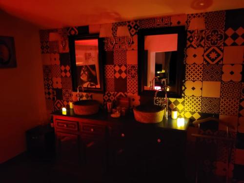 a dark kitchen with a counter and a mirror at La chambres des tentations in Grignan