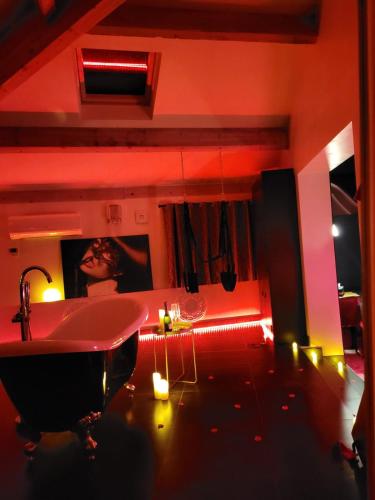 a bathroom with a tub and a sink with lights at La chambres des tentations in Grignan