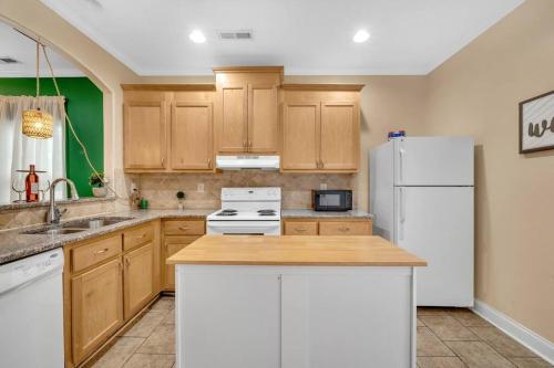 a kitchen with wooden cabinets and a white refrigerator at Cozy 2B Townhouse - Hot Tub in Concord