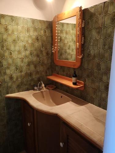 une salle de bain avec un lavabo et un miroir dans l'établissement La Tour dans haut de villa, à Porto-Vecchio