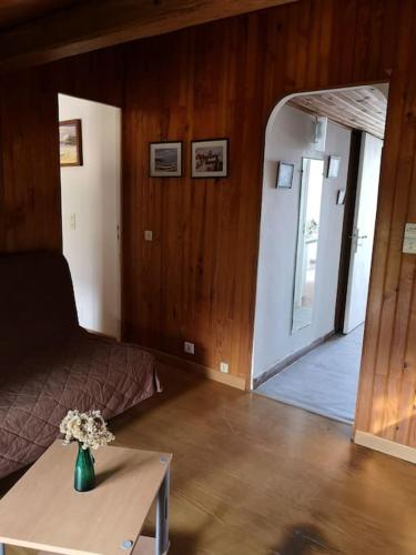 une chambre avec un lit et une table avec un vase de fleurs dans l'établissement La Tour dans haut de villa, à Porto-Vecchio