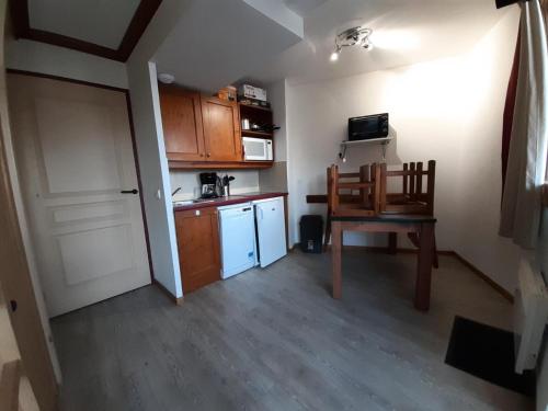 une petite cuisine avec une table et une chaise dans l'établissement Résidence La Marelle et Le Rami - maeva Home - Studio 4 personnes - Sélection MAE-7724, à La Plagne Tarentaise