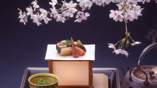 a plate of food on a table next to a flower at Asadaya in Kanazawa