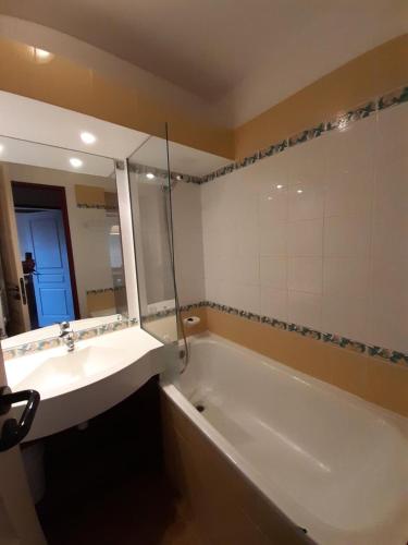 une salle de bain avec un lavabo et une baignoire dans l'établissement Résidence La Marelle et Le Rami - maeva Home - Appartement 2 pièces 5 personnes - Sélection MAE-6804, à La Plagne Tarentaise