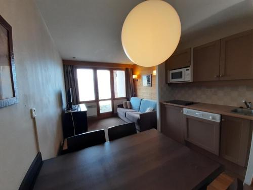 Il comprend une cuisine et un salon avec une table. dans l'établissement Résidence La Marelle et Le Rami - maeva Home - Appartement 2 pièces 4 personnes - Sélection MAE-8614, à La Plagne Tarentaise