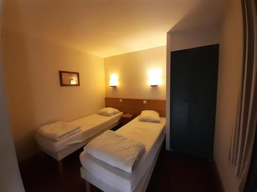 une chambre avec deux lits et deux lumières sur le mur dans l'établissement Résidence La Marelle et Le Rami - maeva Home - Appartement 2 pièces 4 personnes - Sélection MAE-8614, à La Plagne Tarentaise