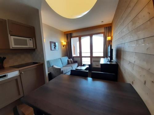 une cuisine et un salon avec une table et un canapé dans l'établissement Résidence La Marelle et Le Rami - maeva Home - Studio 4 personnes - Sélection MAE-4334, à La Plagne Tarentaise