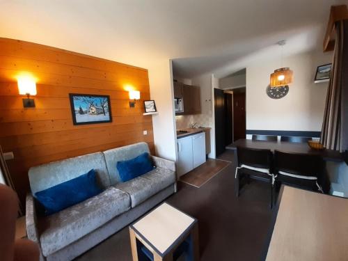 un salon avec un canapé et une cuisine dans l'établissement Résidence La Marelle et Le Rami - maeva Home - Appartement 2 pièces 4 personnes - Sélection MAE-0924, à La Plagne Tarentaise