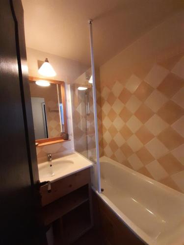 une salle de bain avec un lavabo, une baignoire et un miroir dans l'établissement Résidence La Marelle et Le Rami - maeva Home - Appartement 2 pièces 4 personnes - Sélection MAE-0924, à La Plagne Tarentaise